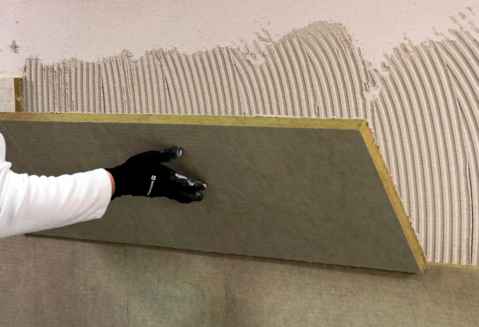 Anschließend die Dämmplatte am vorbereiteten Untergrund andrücken und einschwimmen. Es ist keine Verdübelung erforderlich. (Bild: Heck Wall Systems)